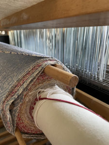 woven towels still on the beam of the loom